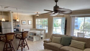 A living room with a beige sofa, a round coffee table, and a dining area with a white table and chairs. - Location! Location! Location!  Sarasota!!! (Sarasota)