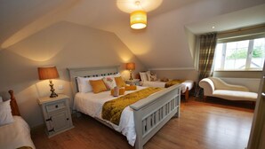 Een slaapkamer met een groot bed, twee nachtkastjes, een stoel en een raam.