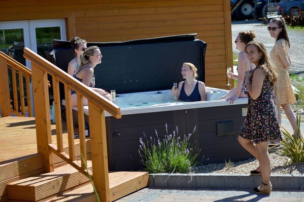 A hot tub with a wooden deck and a small garden area with lavender plants. - Dulrush Fishing Lodge and Guesthouse (Enniskillen)
