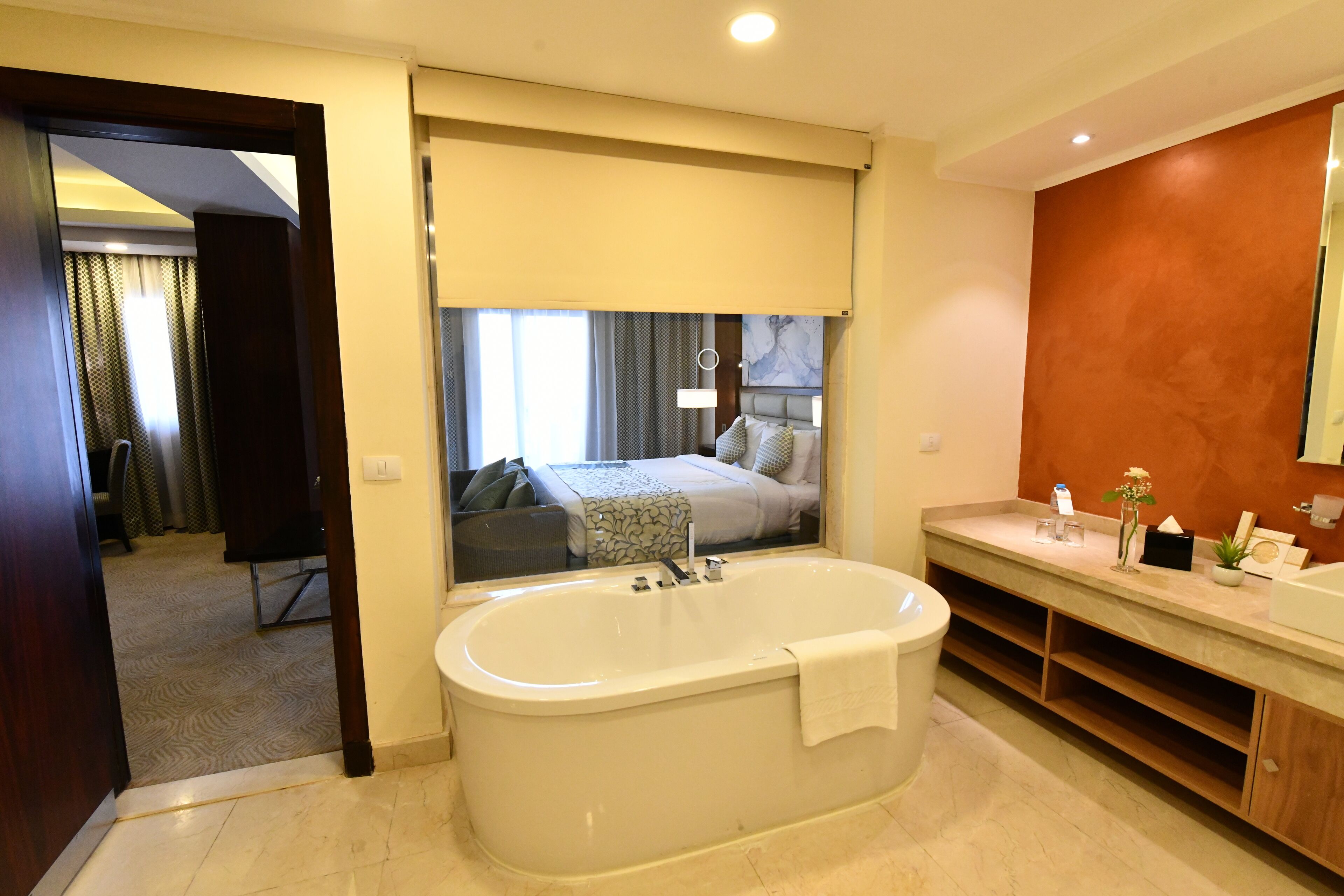 A modern bathroom with a freestanding bathtub, a vanity with a mirror, and a large mirror reflecting the room.