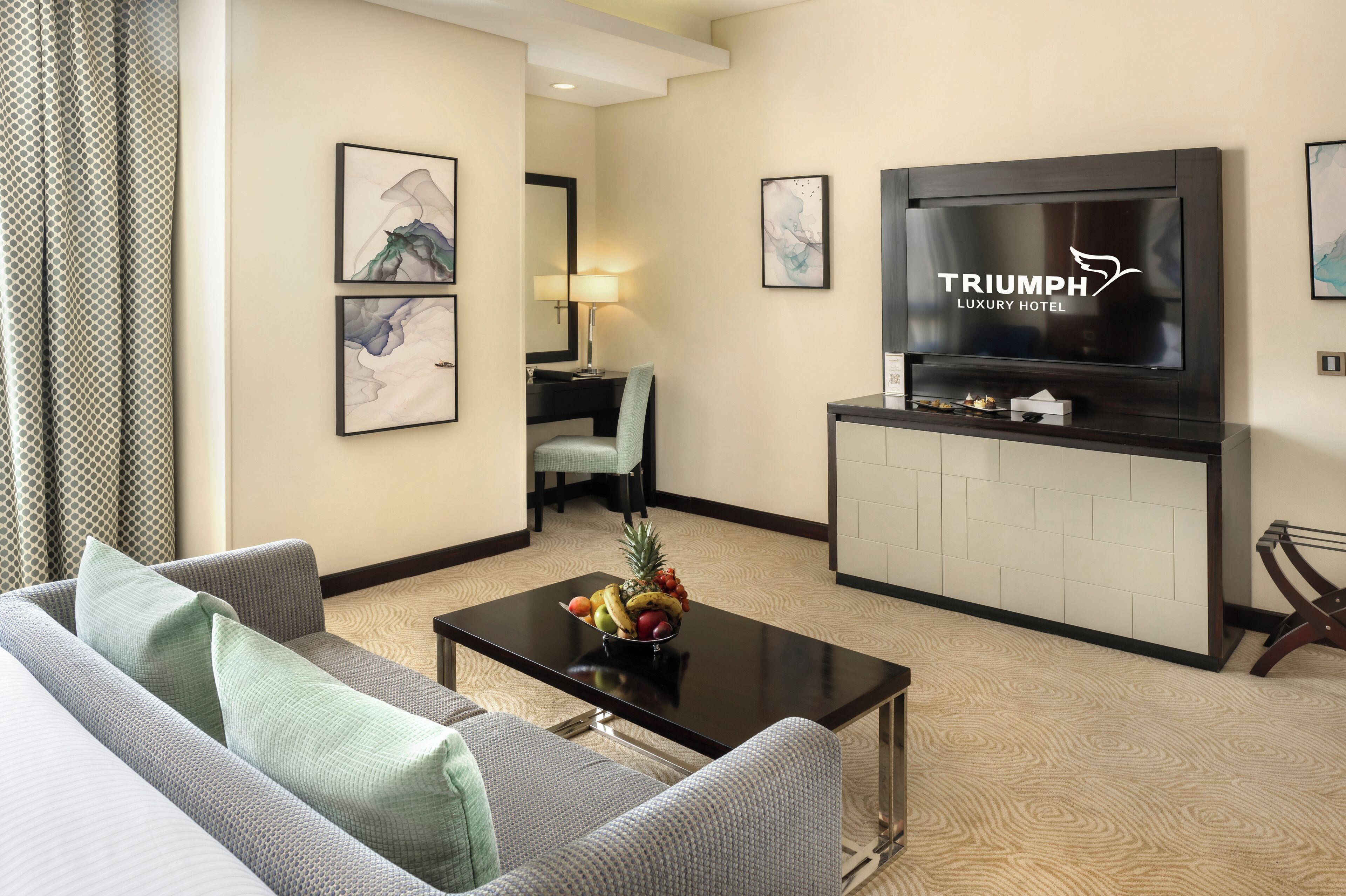 A modern living room with a sofa, coffee table, and a flat-screen TV mounted on the wall.