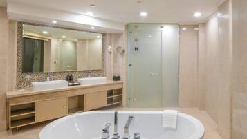 A modern bathroom with a freestanding bathtub, a large mirror, and a glass-enclosed shower.