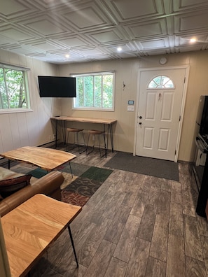 Cozy retreat with a flat-screen TV, wooden table, and comfortable seating for two.