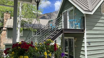 A two-story house with a balcony, a staircase, and a flower arrangement.