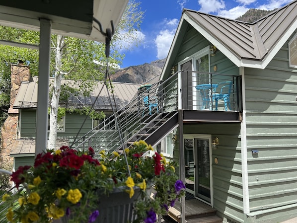 Stunning two-story house with a grand staircase and balcony overlooking the surrounding mountains.