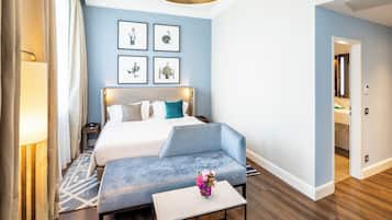Ein modernes Hotelzimmer mit einem großen Bett, einer Sitzecke und Kunstwerken an den Wänden.
