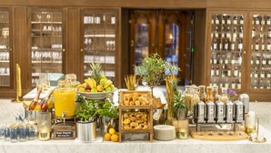 A buffet setup with various food items, drinks, and a wine display in a hotel setting. - Fraser Suites Hamburg (Hamburg)