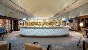A modern hotel lobby with a central bar area, seating arrangements, and a well-lit ceiling. - Fraser Suites Hamburg (Hamburg)