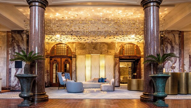 A grand lobby with marble columns, a chandelier, and a seating area. - Fraser Suites Hamburg (Hamburg)