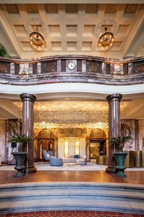 A grand lobby with marble columns, a chandelier, and a seating area. - Fraser Suites Hamburg (Hamburg)