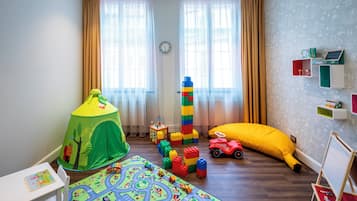 Ein Kinderzimmer mit Spielmatte, Zelt, Spielzeugauto und Klettergerüst.