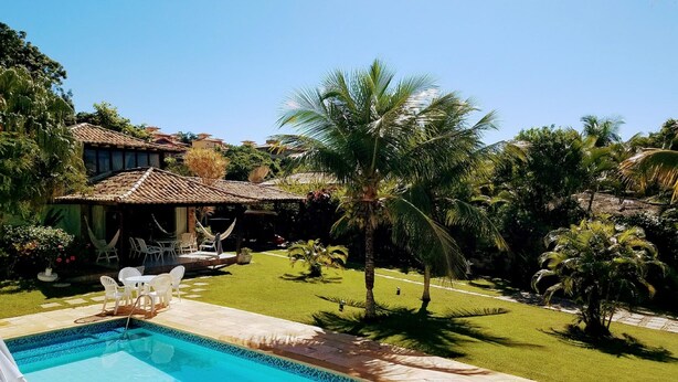 A pool area with a tiled deck, a hammock, and outdoor furniture. - Linda casa a 150 mts da Praia Ferradura (Búzios)