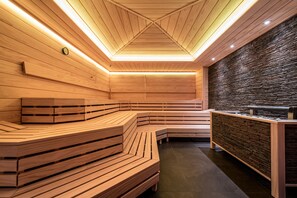 Uma sauna com bancos de madeira e parede de pedra.