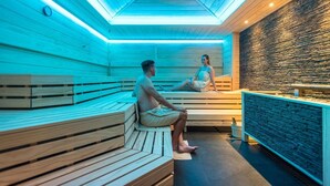 Un sauna avec des bancs en bois et un mur en pierre.