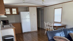 A compact living space with a kitchenette, a dining area, and a seating area with a sofa. - Book longer and save weekly plus monthly discounts (Hayesville)