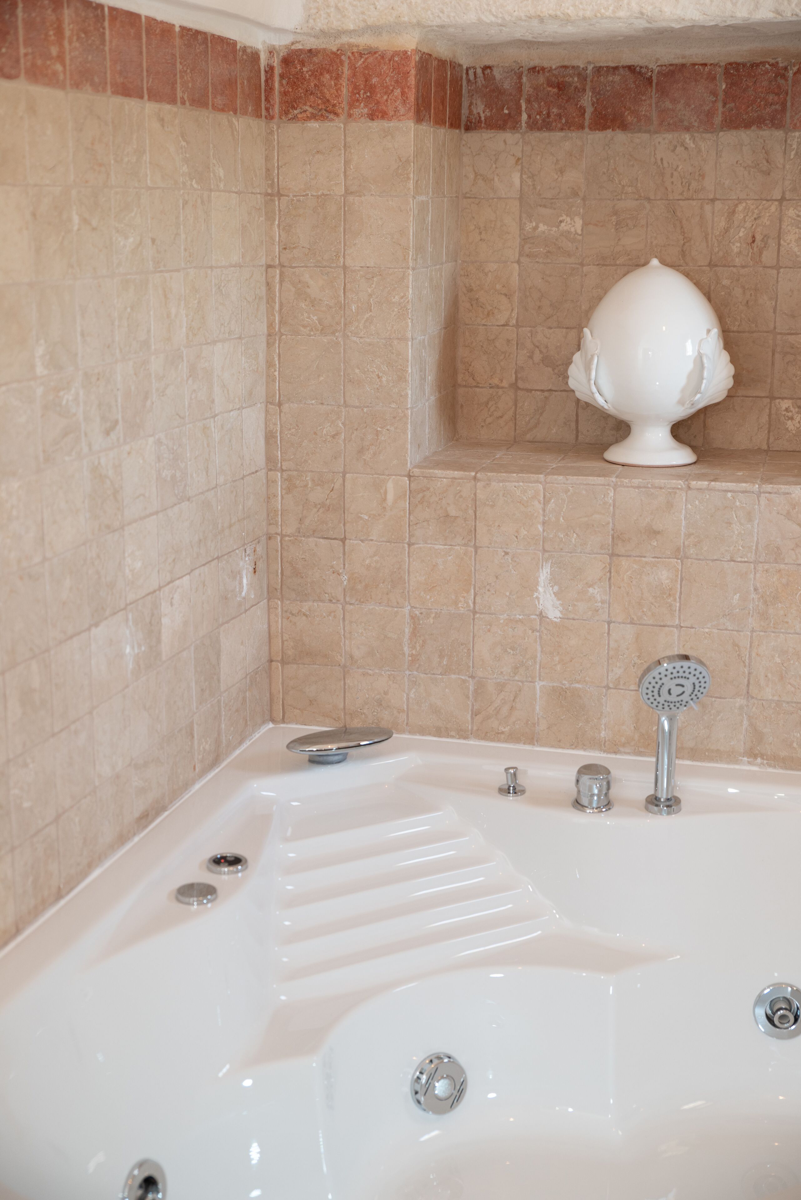 A bathroom with a bathtub, a showerhead, and a decorative item on the wall.