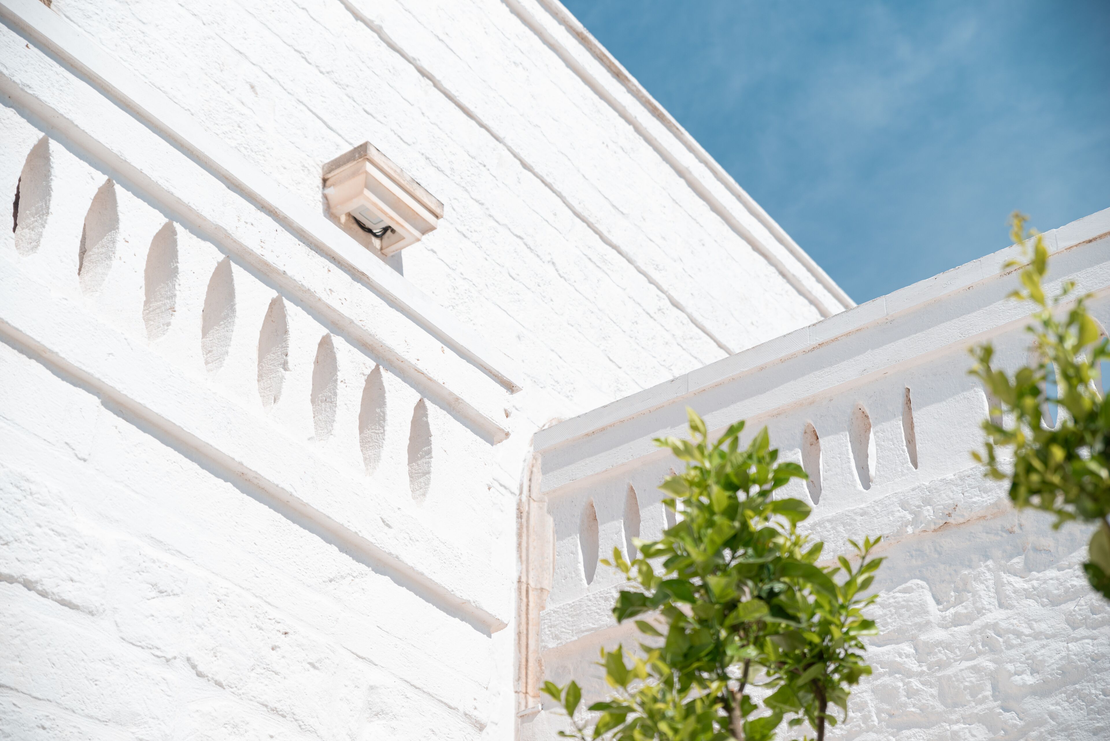 A white building with a window and a door with decorative cutouts.