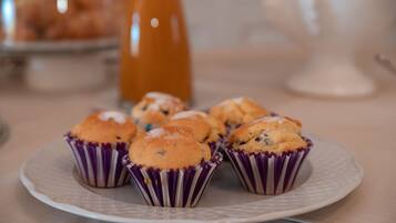 Un plato con muffins en vasos de papel morados sobre un plato blanco.