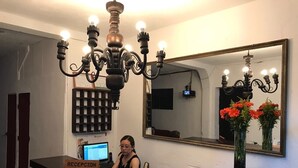 Un mostrador de recepción con un cartel que dice "RECEPCION", una computadora y una araña.