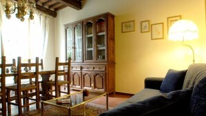 Una sala de estar con un aparador de madera, un sofá y una mesa.