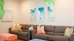 A living room with two sofas, a coffee table, and a painting of palm trees. - ❀Aloha❀ - Tropical Island Retreat | POOL IS OPEN!!! Great Family Friendly Vacation! (Washington)
