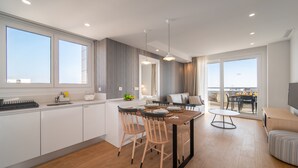 A modern kitchen with a dining area, large windows, and a balcony with a view. - Ahoy Apartments (El Campello)