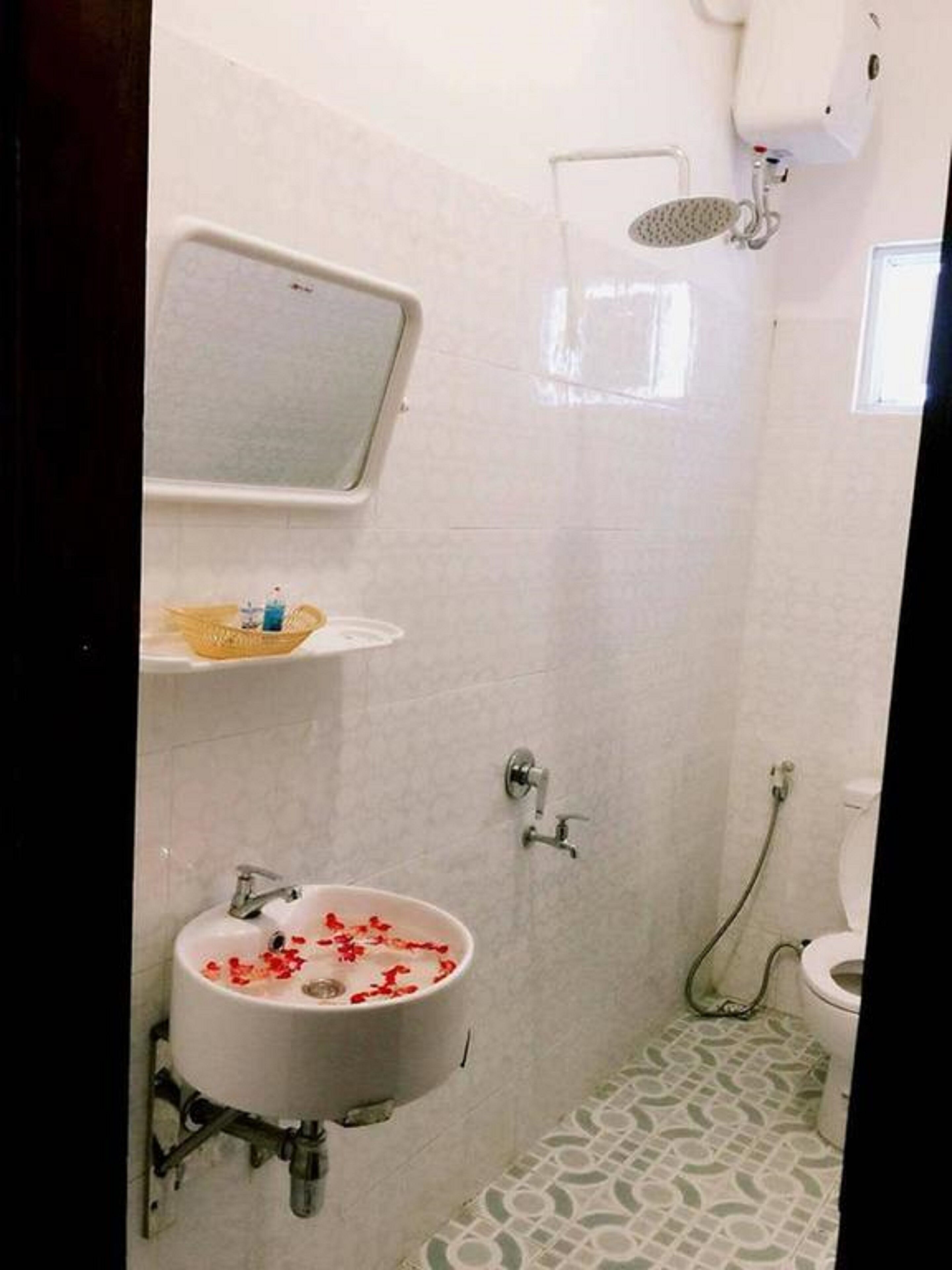 A bathroom with a sink, shower, and toilet.