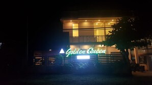 A two-story building with a neon sign reading "Golden Queen." - Golden Queen Guest House (Ngapali)