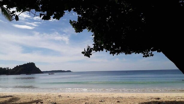 A beach with clear water, a sandy shore, and a distant island. - Golden Queen Guest House (Ngapali)