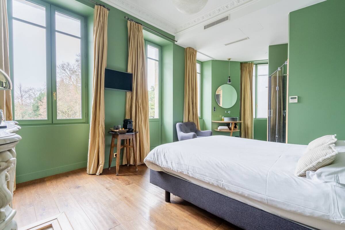 Un dormitorio con cama, escritorio, silla, espejo y armario.