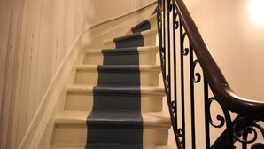 Eine Treppe mit einem schwarz-weiß gestreiften Geländer und einem hölzernen Geländer.