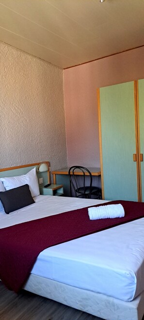 A hotel room with a bed, a desk, a chair, and a wardrobe. - Hotel Restaurant Les Alizes (Le Pouzin)