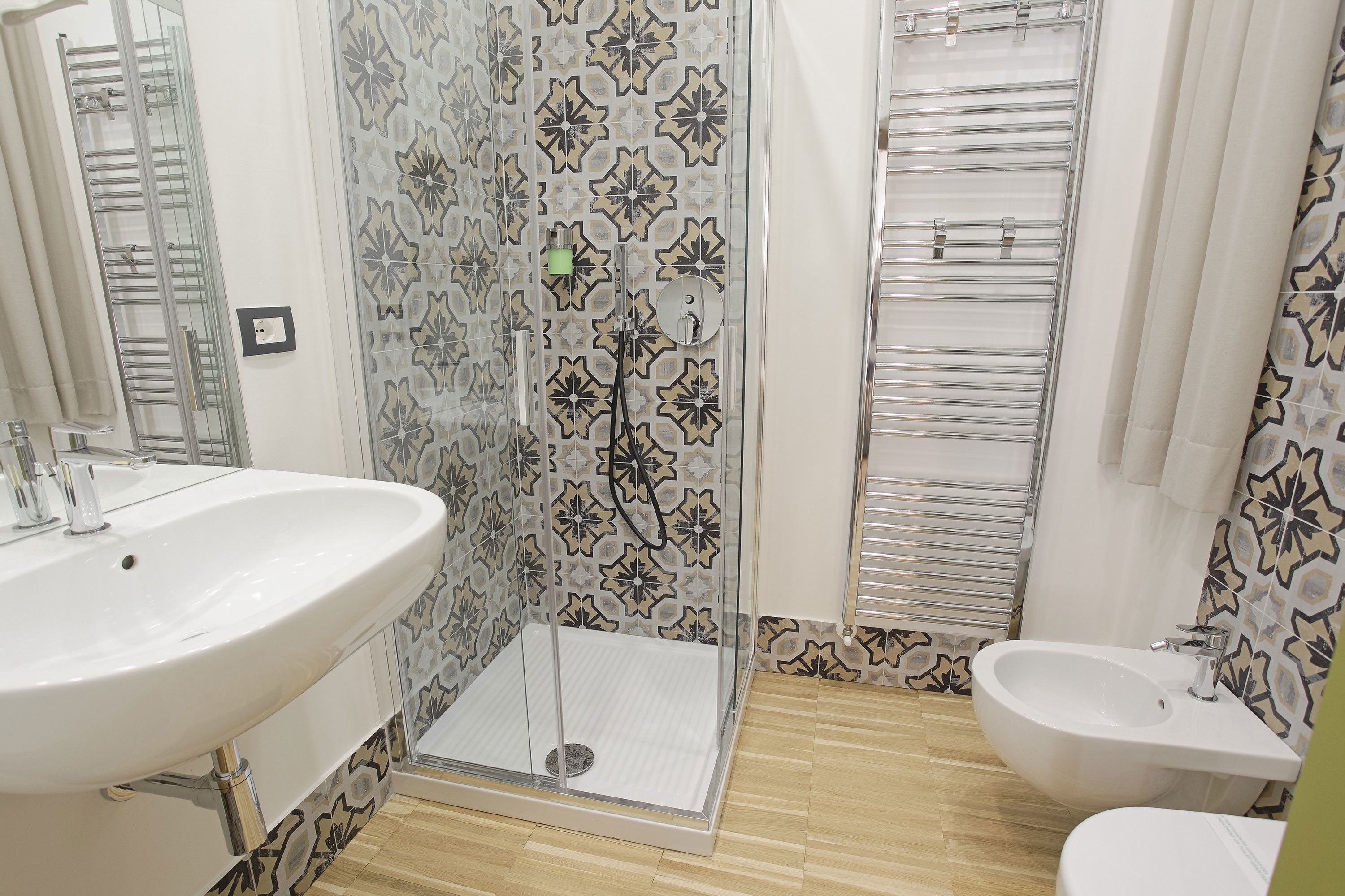 A bathroom with a shower, sink, and bidet.