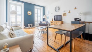 Una sala de estar moderna con un sofá, una mesa de comedor y un televisor.