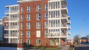A multi-story residential building with balconies, large windows, and a brick facade. - Wohnen am Yachthafen W45 (Cuxhaven)