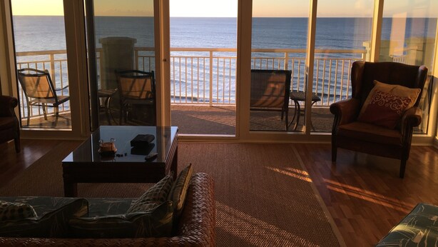 A spacious living room with a large glass door leading to a balcony with ocean views. - THANK YOU 2025 RENTERS for 100%. 2026 only 3 weeks left DIRECT OCEAN FRONT 5BR  (Myrtle Beach)