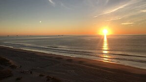 A beach with the sun setting over the horizon, calm sea, and a clear sky. - THANK YOU 2025 RENTERS for 100%. 2026 only 3 weeks left DIRECT OCEAN FRONT 5BR  (Myrtle Beach)
