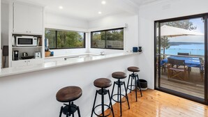 A modern kitchen with a large window, a built-in microwave, and a bar area with stools.