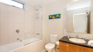 Ein modernes Badezimmer mit Badewanne, Toilette und Waschbecken.