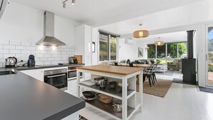 Een moderne keuken met een centraal eiland, een ingebouwde oven en een groot raam.