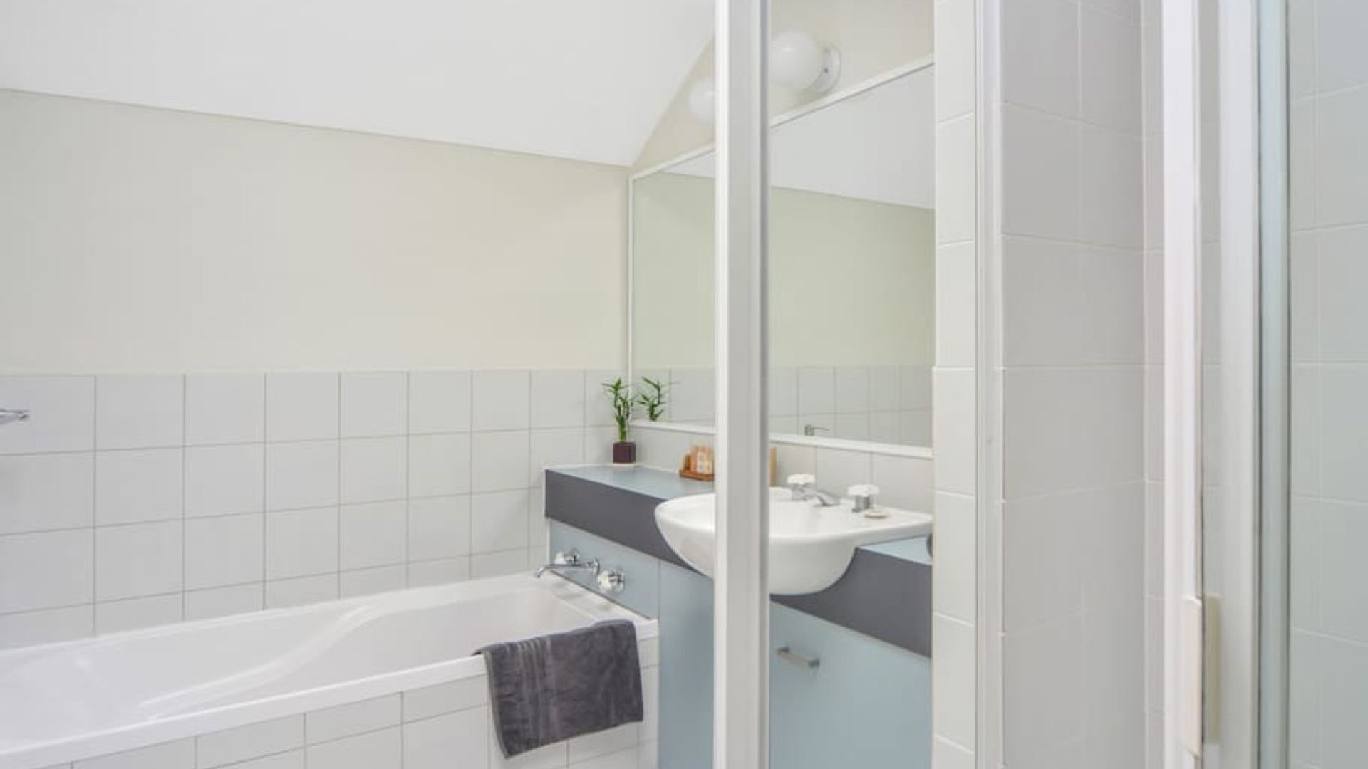 Ein modernes Badezimmer mit einer Badewanne, einem Waschbecken und einem Spiegel.