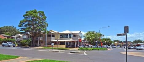 A street view with a two-story building, a clear sky, and a sign for Hawke St.