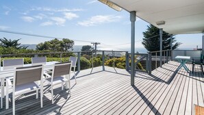 A wooden deck with outdoor seating and a view of the landscape.