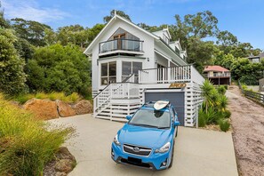 A two-story house with a garage, a balcony, and a car parked in front. - Argo (Lorne)