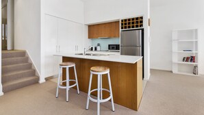 Eine moderne Küche mit einer zentralen Kochinsel, Edelstahlgeräten und Holzelementen.