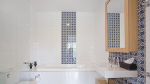 A bathroom with a bathtub, a toilet, and a sink. - Four Kings 3 (Anglesea)