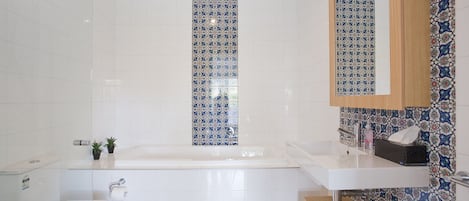 Un baño con bañera, inodoro y lavabo.