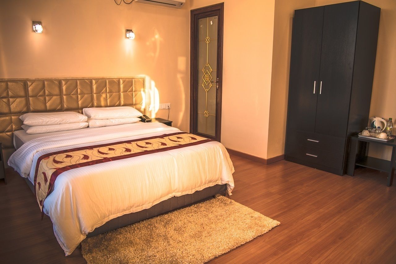 Une chambre à coucher comprenant un lit, une armoire, une table de chevet et une petite table avec une lampe.