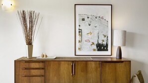 A wooden cabinet with drawers and a vase of dried branches on top. - Apartment 25 Kalimna (Lorne)
