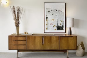 A wooden cabinet with drawers and a vase of dried branches on top. - Apartment 25 Kalimna (Lorne)
